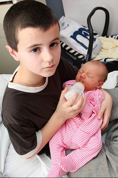 Alfie sosteniendo a Maisie, su hija que parece su hermana