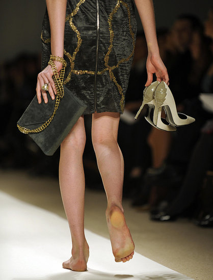 modelo sigue desfilando con los zapatos en la mano