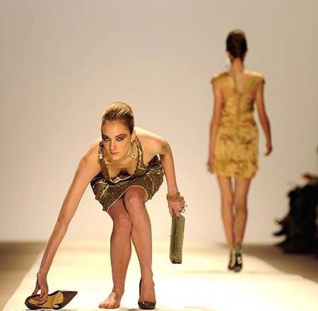 modelo tropieza en desfile y recoge sus tacones