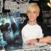 tom felton con su poster autografiado Tom Felton sonriente firmando un poster