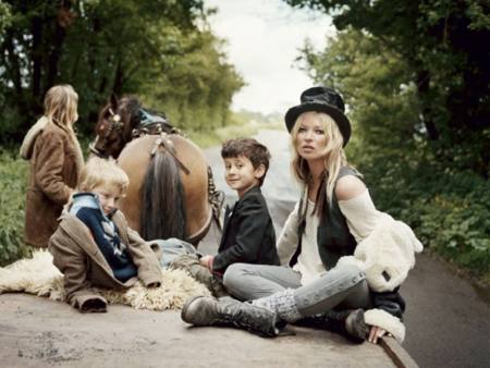 Kate Moss con un look bohemio en una carreta con niños