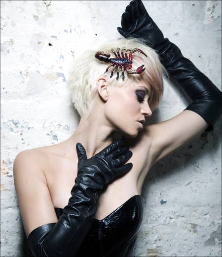 Kimberly Wyatt con un accesorio de escorpion, corset y guantes negros