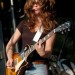 Miley Cyrus tocando una guitarra Les Paul Milye Cyrus en escenario con una guitarra Les Paul
