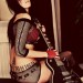 Chica con ropa de malla, tocando su guitarra Les Paul Mujer con su guitarra Les Paul, sentada y esperando a tocar