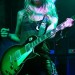 Guitarrista con su instrumento Les Paul Chica en escenario con una guitarra Les Paul de 3 colores