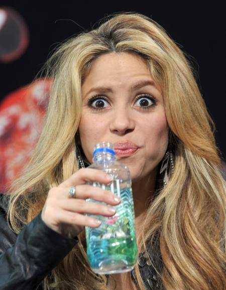 Shakira haciendo un gesto raro mientras sostiene una botella de agua