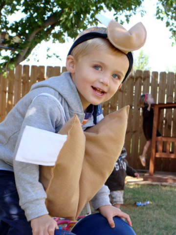 niño sonriente con disfraz de galleta de la fortuna