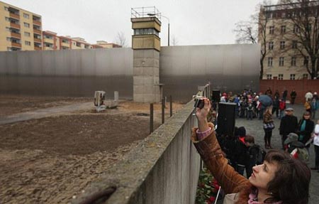 turista tomando una foto sobre la parte que aun existe del Muro de Berlín