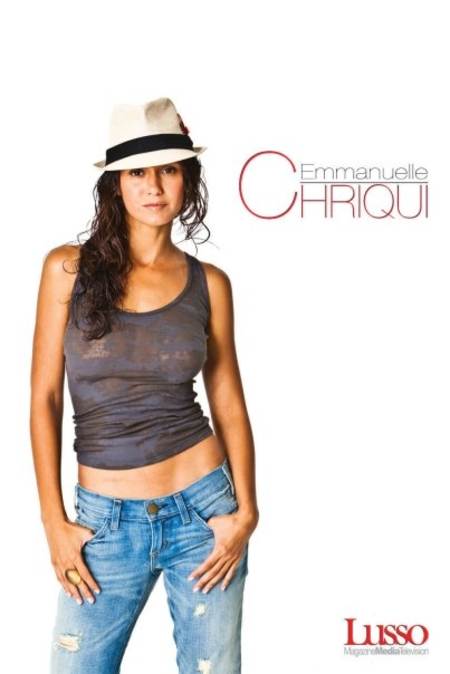 Emmanuelle Chriqui posando sexy con un top gris, jeans y un sombrero