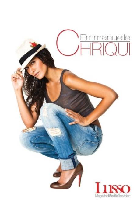 Emmanuelle Chriqui en cuclillas tomando su sombrero por la punta