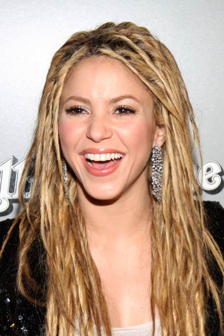 Shakira sonriendo ampliamente a su llegada a la fiesta