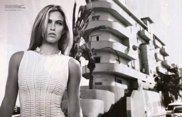 Bar Refaeli con vestido blanco posando ante un hotel