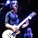 Brian Molko tocando la guitarra luciendo fashion