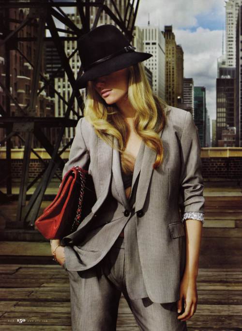 Brooklyn Decker con traje sastre y sombrero posando muy fashion