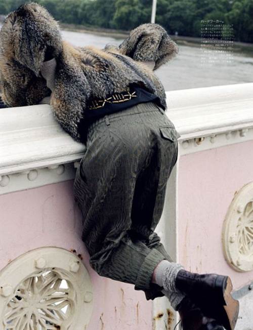 Dree Hemingway con un saco de piel pantalones y botas, viendo el lago