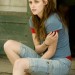 Kristen Stewart sentada en la entrada mirando a alguien