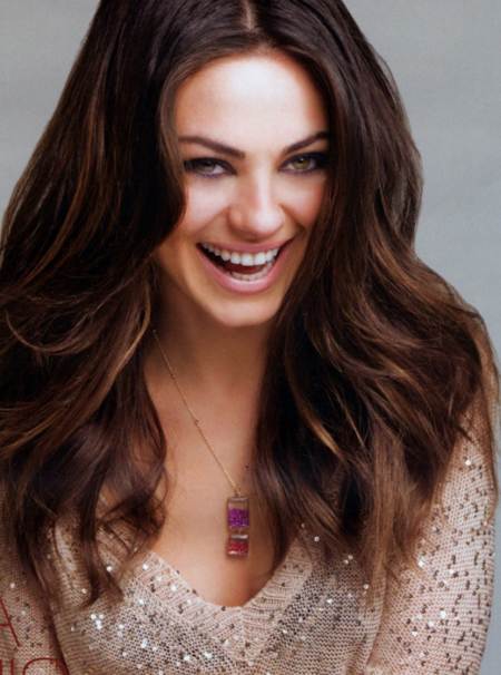 Mila Kunis posando para H en un closeup de su rostro luciendo feliz