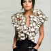 Mila Kunis posando con blusa floreada y con faldon negro