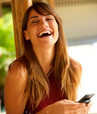 Mujer riendo con el movil en la mano