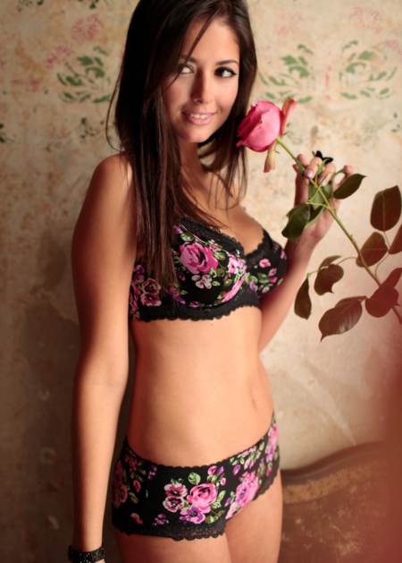 Carla Ossa posando conjunto floreado con una flor rosa