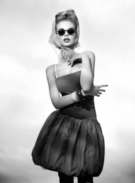 Dioni Tabbers posando vestido negro con mascada y lentes retro
