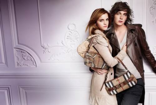 Emma Watson con chaqueta y bolsos posando con un modelo