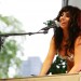 Lady GaGa sonriente mientras canta y toca el piano