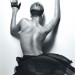Rihanna con una falda y guantes, mostrando la espalda desnuda