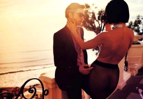 Robert Pattinson posando con una modelo topless