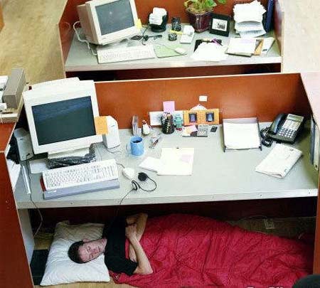 Mujer dormida debajo del escritorio