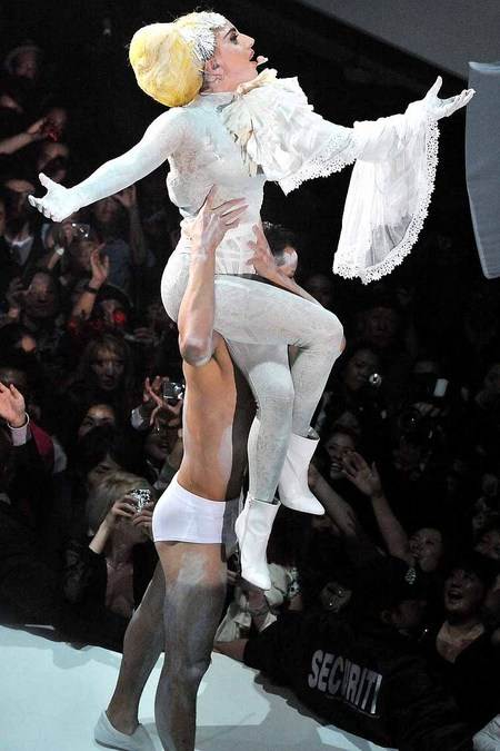 Lady GaGa cantando mientras la carga un bailarin