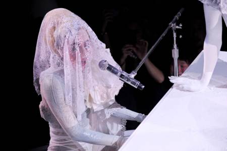 Lady GaGa tocando el piano con un velo de encaje