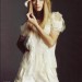 Taylor Swift posando con vestido blanco elegante y sombrero fashion
