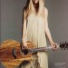 Taylor Swift con guitarra electroacustica y vestido hippie suelto