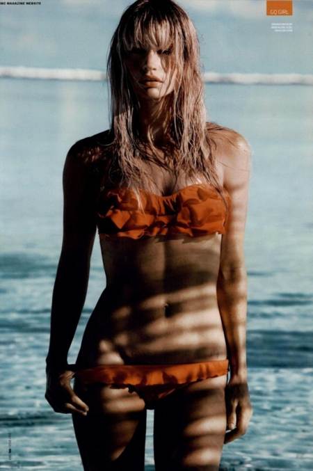 Cameron Richardson con bikini anaranjado caminando en el mar