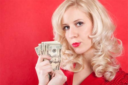Mujer rubia posando con dinero