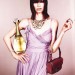 Luca Gadjus con vestido purpura, bolso y perfume, elegante