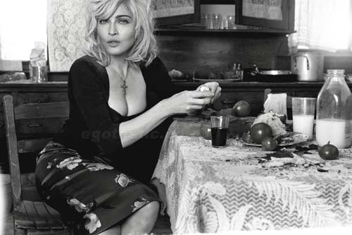 Madonna sentada junto a la mesa, partiendo fruta.
