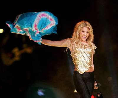 Shakira sosteniendo una pañoleta azul con una sonrisa sensual hacia el publico