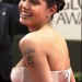 Actriz Angelina Jolie, en entrega de premios, posando de perfil un vestido rosa strapless, mostrando el tatuaje en su brazo