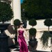 Angelina Jolie posando en un jardín de árboles con un vestido largo de seda color morado tipo strapless.