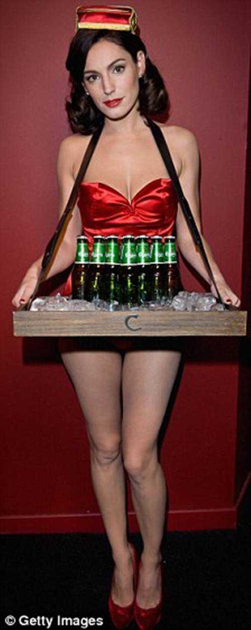 De frente, el escote de Kelly Brook nos deja con una amplia sonrisa en el rostro mientras ofrece cerveza a los nuevos clientes