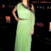 Nikki Reid con un vestido elegante color verde posando en la alfombra roja